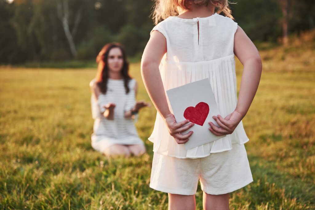 child s daughter congratulates her mother gives her postcard